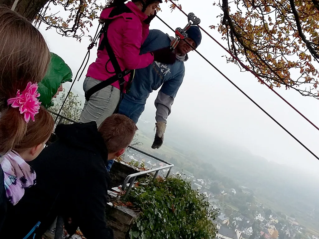 Person startet in die Seilrutsche, andere schauen zu.